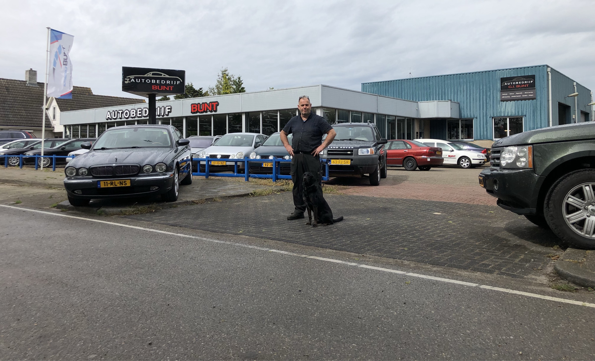 Autobedrijf Bunt aan de Constructieweg in Kampen, met Anno Bunt en zijn hond Rusty voor de gevel