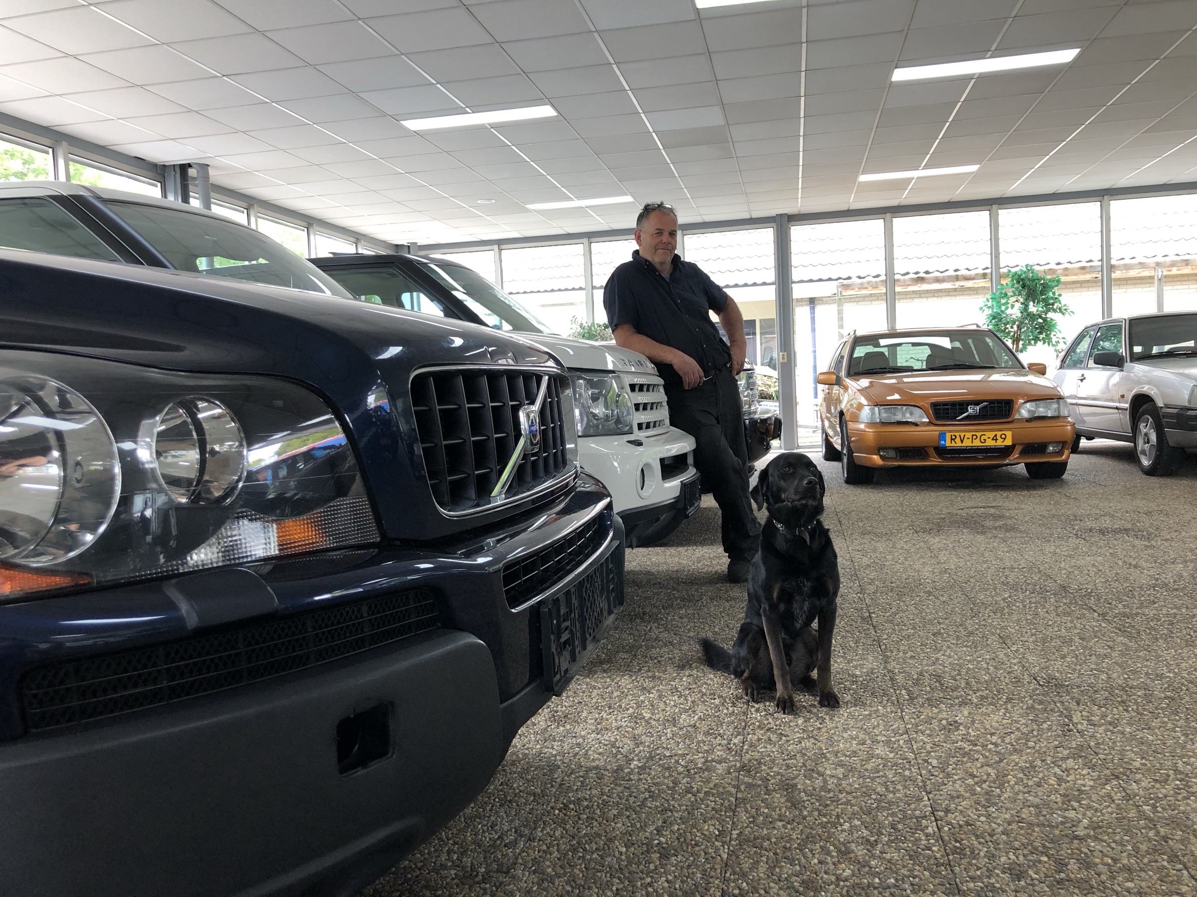 Anno Bunt en Rusty in de showroom, tussen een Volvo XC90 en een oranje Volvo C70