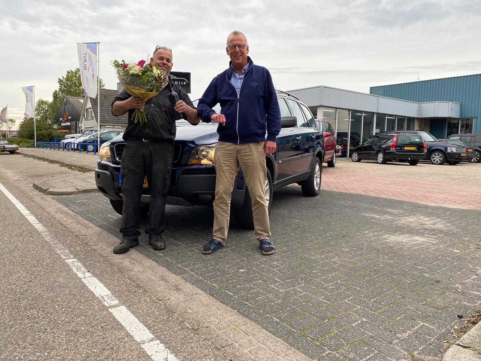 Anno Bunt overhandigt een Volvo XC90 met een bos bloemen aan een klant